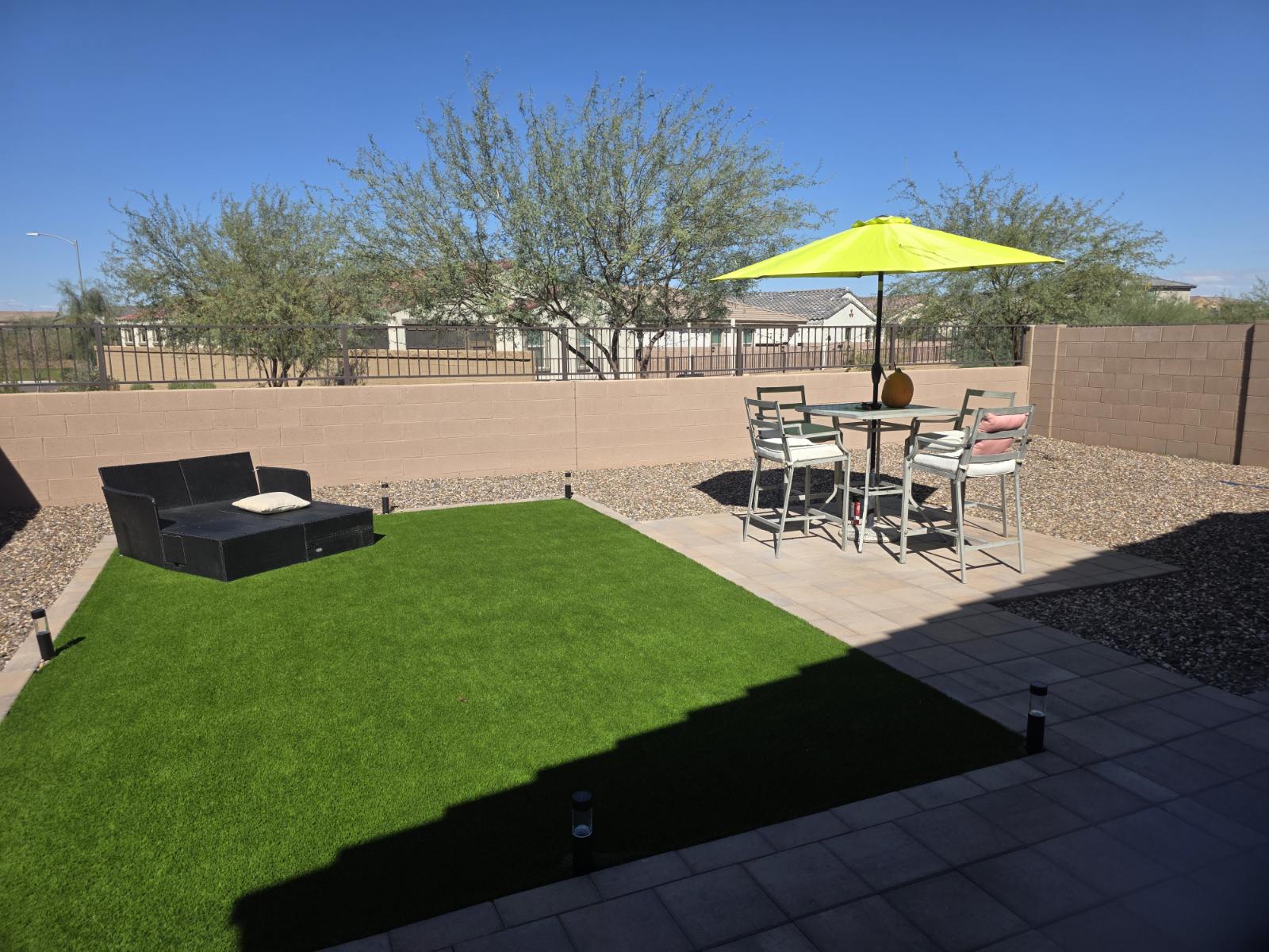 A residential backyard patio with outdoor furniture and greenery